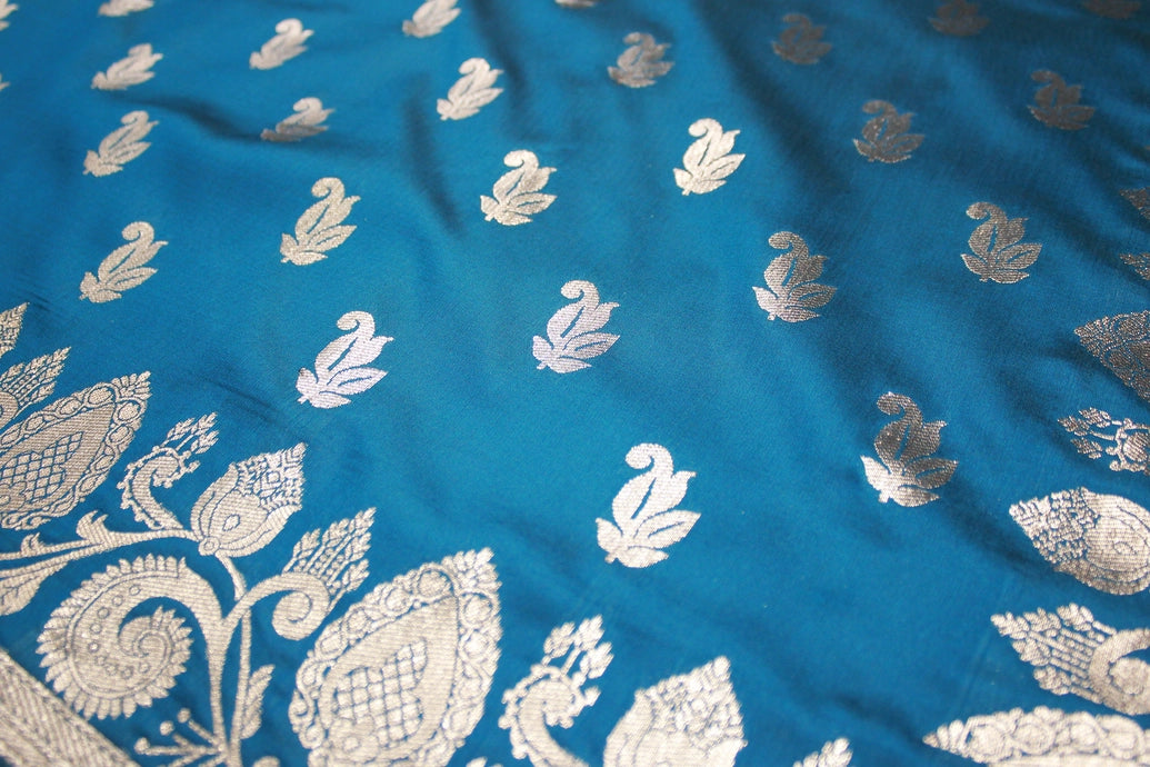 beautifully adorned with intricate zari weaving banarasi saree. The saree features delicate floral and mango motifs woven across the body, c