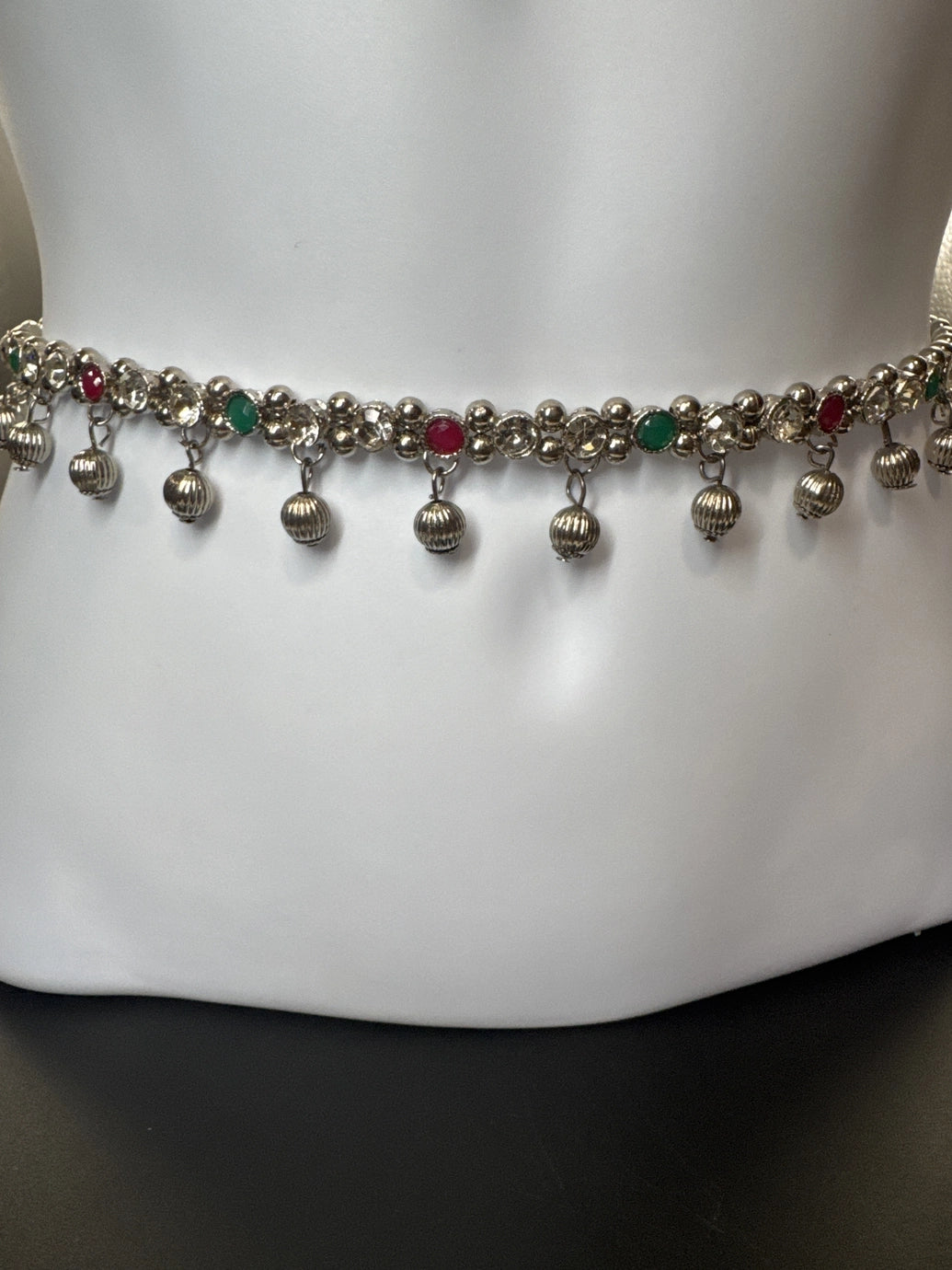 Silver-tone hip chain with oxidized finish, multicolor imitation stone accents, and ghungroo bell detailing, elegant traditional design with