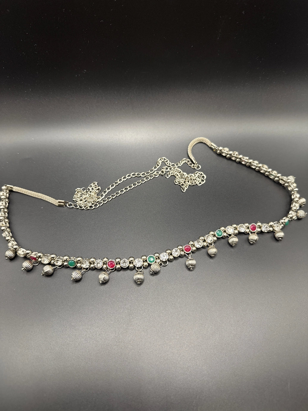 Silver-tone hip chain with oxidized finish, multicolor imitation stone accents, and ghungroo bell detailing, elegant traditional design with