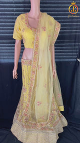 Heavy designer lehenga with embroidery and stone work in a pleasant yellow